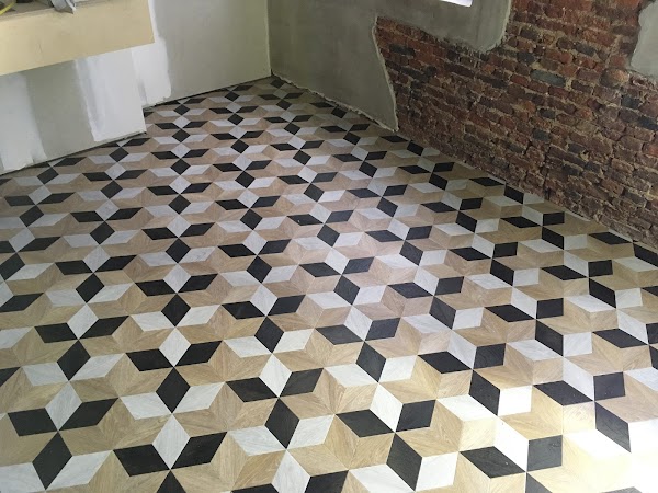PVC vloer met cube-patroon in zwart, wit en hout, geplaatst tijdens een renovatie